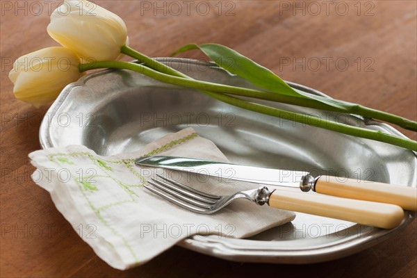 Tulips on plate with cutlery.