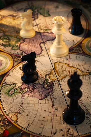 Chess pieces on old world map.