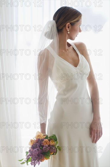 Bride holding floral bouquet.