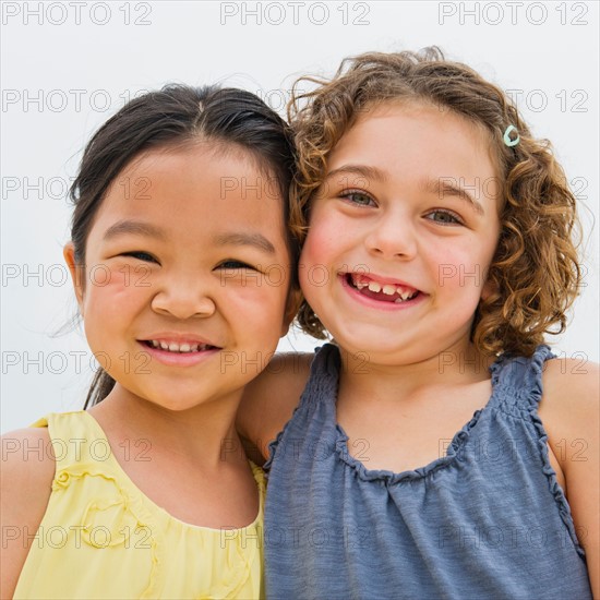 Portrait of two girls (6-7) embracing.