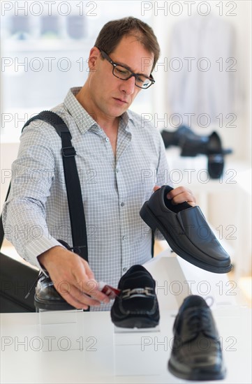 Man choosing shoes in store.