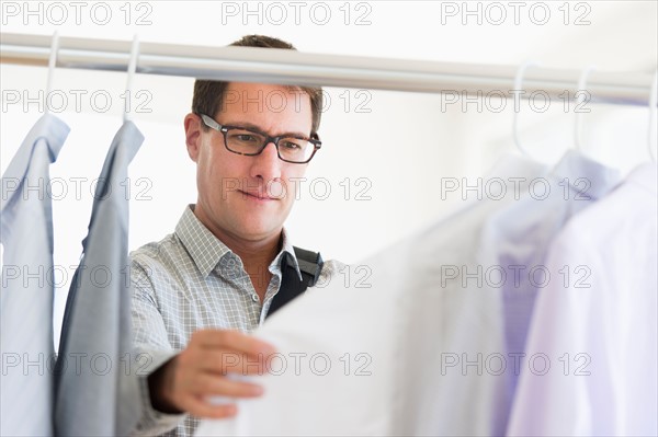 Man choosing shirts in store.