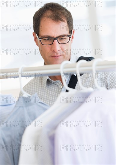 Man choosing shirts in store.