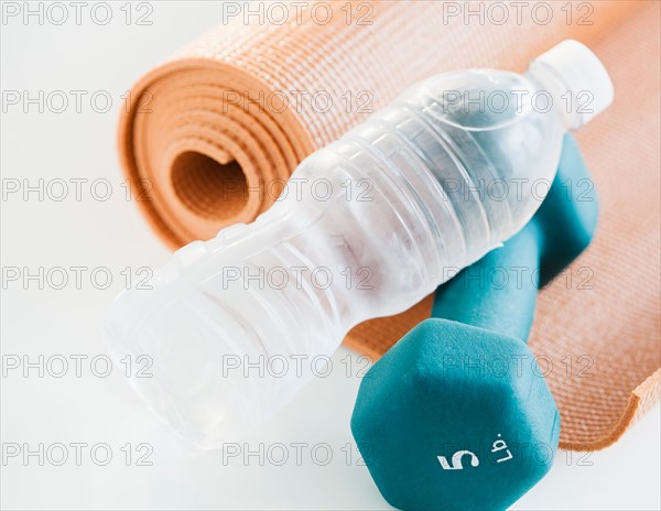 Exercise mat, water bottle and weights, studio shot. Photo : Jamie Grill