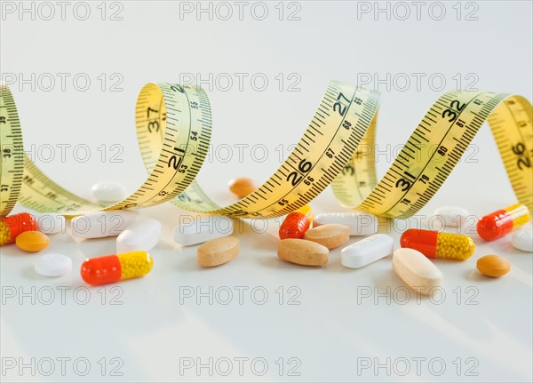 Tape measure, pills and capsules, studio shot. Photo: Jamie Grill