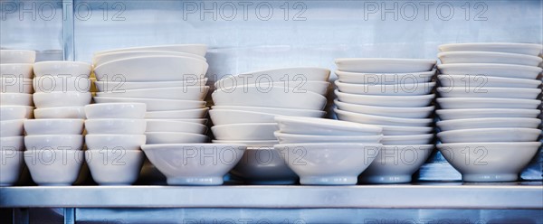 Stacked plates and bowls in kitchen.