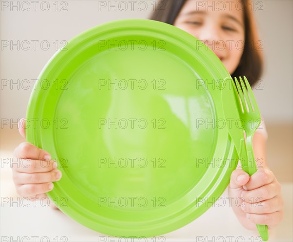 Close up of girl (8-9) with green plate. Photo : Jamie Grill