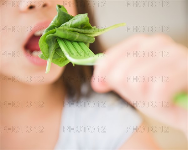 Close up of girl (10-11) eating salad. Photo : Jamie Grill
