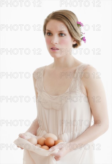 Young woman carrying basket of eggs.