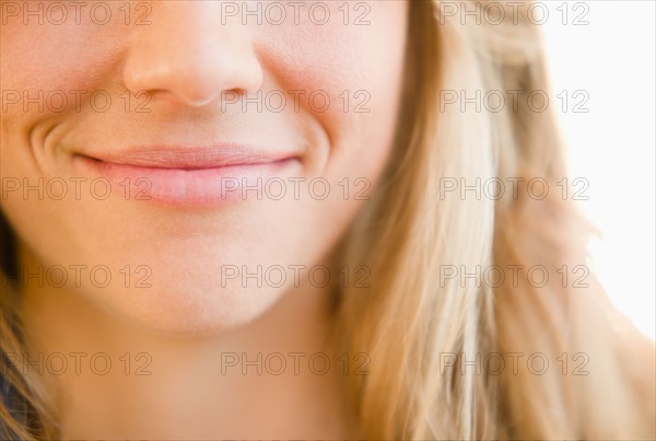 Close up of mouth of smirking woman. Photo : Jamie Grill