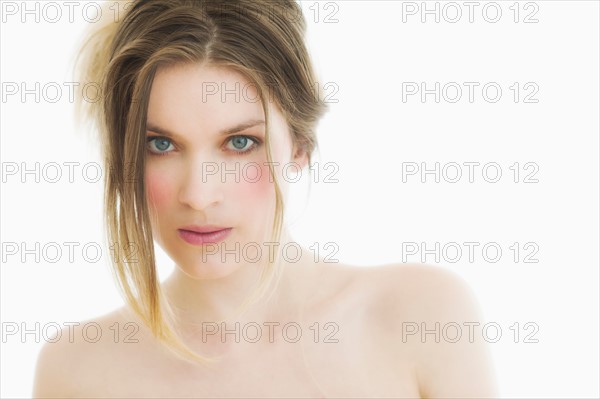 Studio portrait of young woman with brown hair.