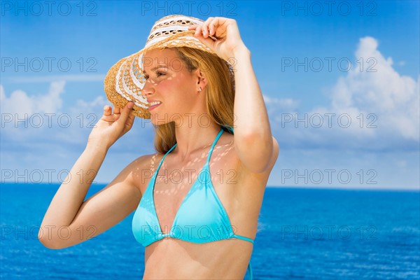 Woman wearing bikini by sea.