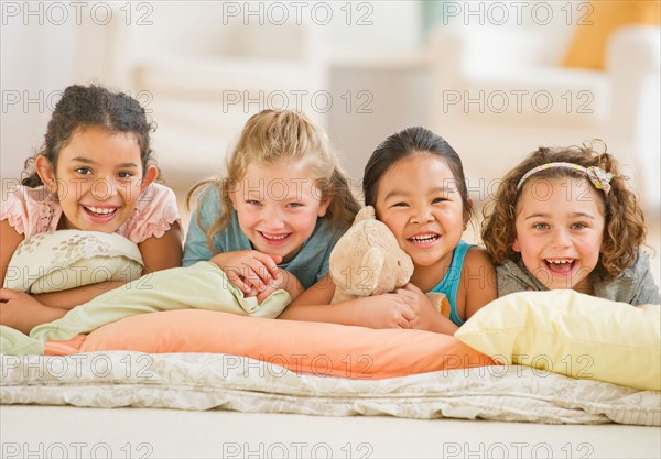 Portrait of girls (6-9) relaxing on pillows.