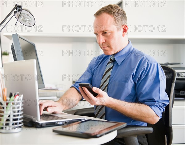 Businessman working in office. Photo : Jamie Grill