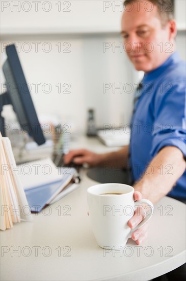 Businessman working in office. Photo : Jamie Grill