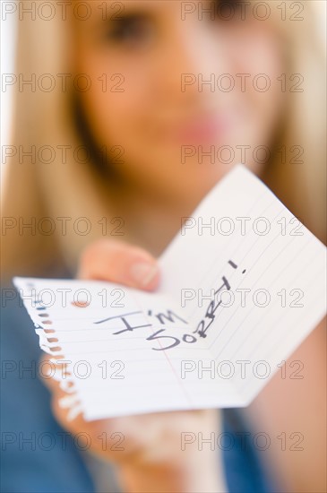 Close up of woman showing apologize message. Photo: Jamie Grill