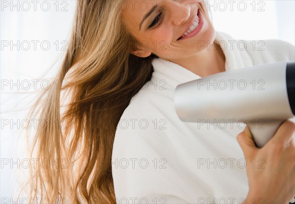 Woman drying hair. Photo : Jamie Grill