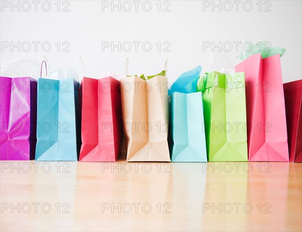 Colorful shopping bags standing in row. Photo : Jamie Grill