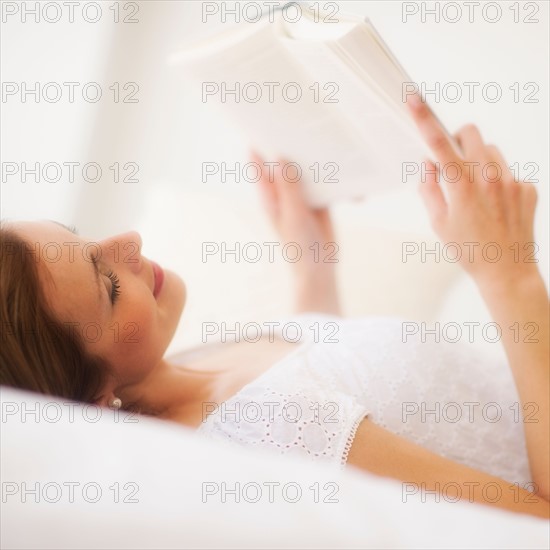 Sensual portrait of young woman reading book. Photo: Daniel Grill