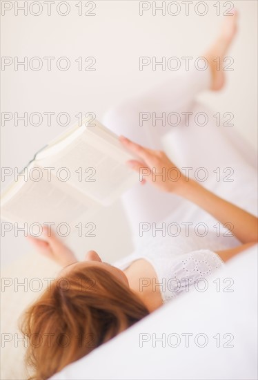 Sensual portrait of young woman reading book. Photo : Daniel Grill