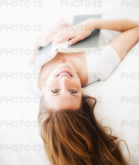 Sensual portrait of young woman reading book. Photo: Daniel Grill
