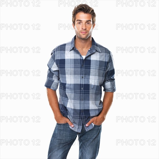 Studio shot of young confident man with hands in pockets. Photo : momentimages