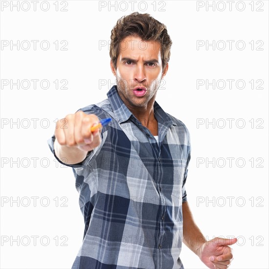 Studio shot of young confident man pointing with pen at camera. Photo : momentimages