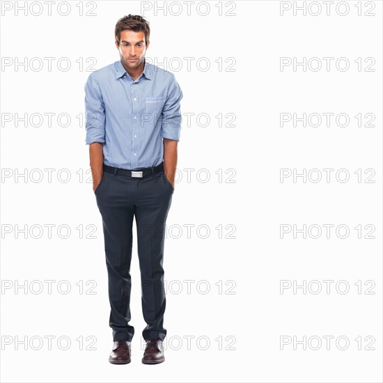 Business man standing with hands in pockets and looking down. Photo : momentimages
