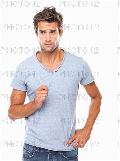 Studio shot of young man with furrowed forehead looking away. Photo: momentimages