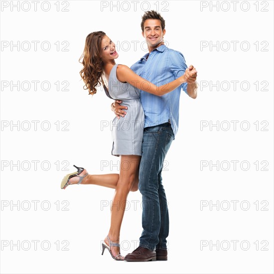 Studio shot of young couple dancing together and smiling. Photo : momentimages