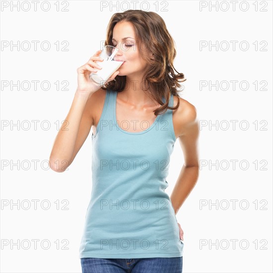 Studio shot of attractive young woman drinking milk. Photo : momentimages