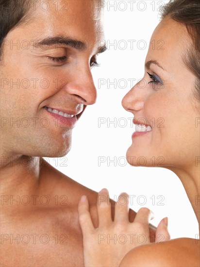 Studio portrait of young attractive couple looking at each other. Photo: momentimages