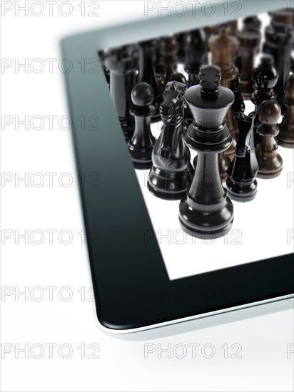 Studio shot of black chess queen and black chess pawns on tablet. Photo : David Arky