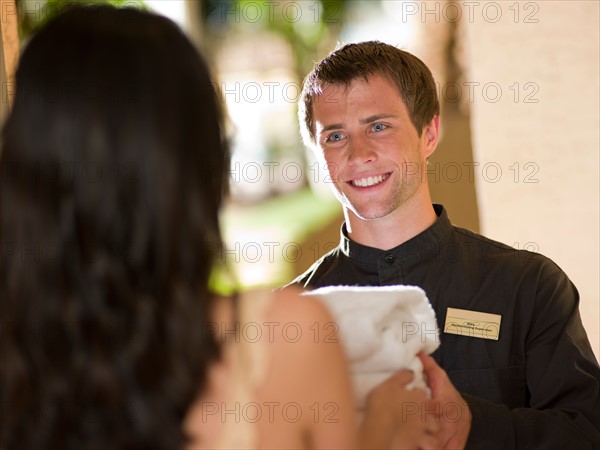 Man from room service delivering towels to hotel guest. Photo : db2stock