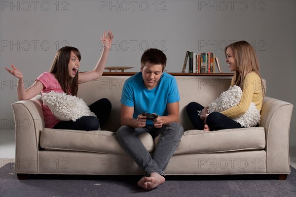 Portrait of teenage boy (16-17) and girl (16-17) with young friend. Photo : Rob Lewine