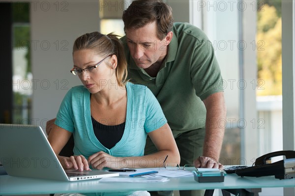 Mature couple working on laptop at home. Photo : Rob Lewine