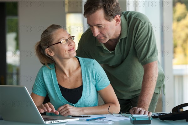 Mature couple working on laptop at home. Photo: Rob Lewine