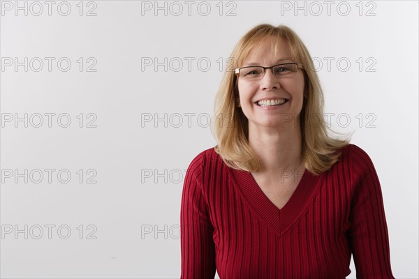 Portrait of mature woman, studio shot. Photo : Rob Lewine