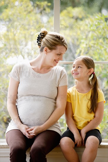 Daughter (6-7) sitting next to pregnant mother. Photo : Rob Lewine