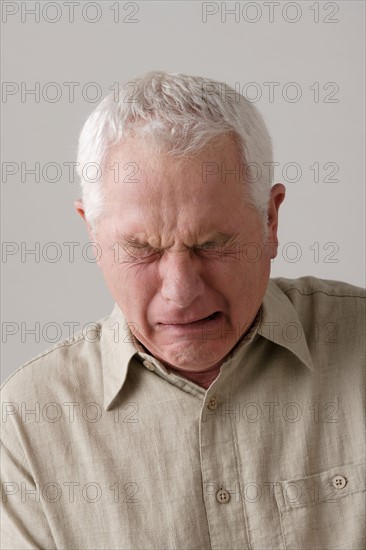 Portrait of senior man crying, studio shot. Photo : Rob Lewine