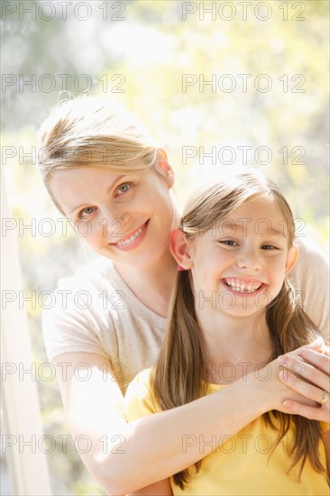Portrait of daughter (6-7) and mother embracing. Photo : Rob Lewine