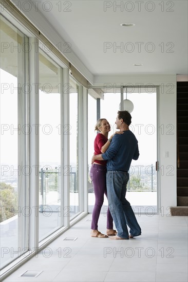 Mature couple dancing in empty living room. Photo : Rob Lewine