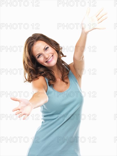 Studio portrait of attractive young woman reaching hands towards camera. Photo: momentimages