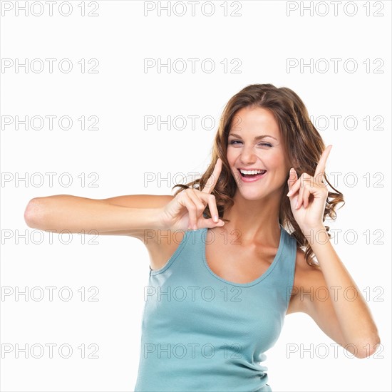 Studio portrait of attractive young woman gesturing and winking. Photo : momentimages