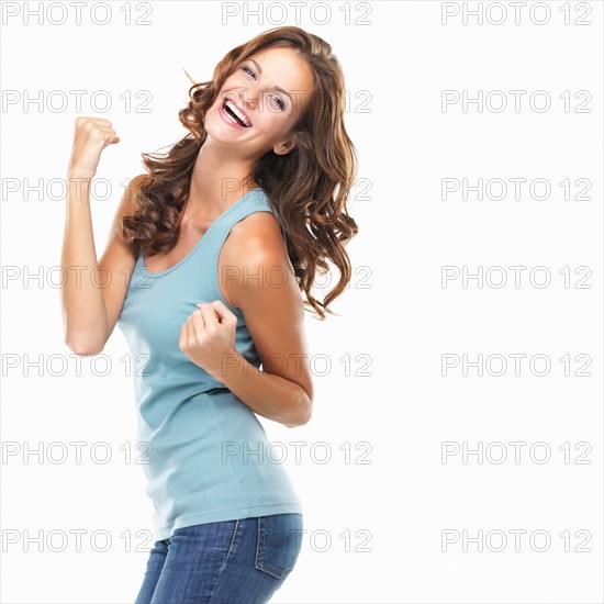 Studio portrait of attractive young woman celebrating success. Photo: momentimages