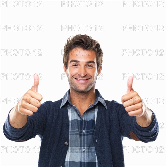 Studio shot of young man with two thumbs up. Photo: momentimages