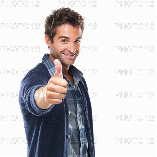 Studio shot of young with thumbs up. Photo : momentimages
