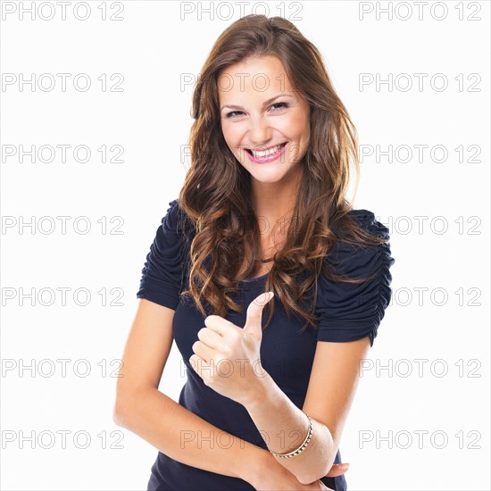 Studio shot of young woman with thumbs up. Photo : momentimages