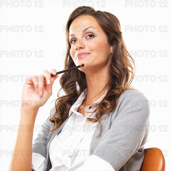 Bored business woman sitting on chair with pencil against white background. Photo : momentimages