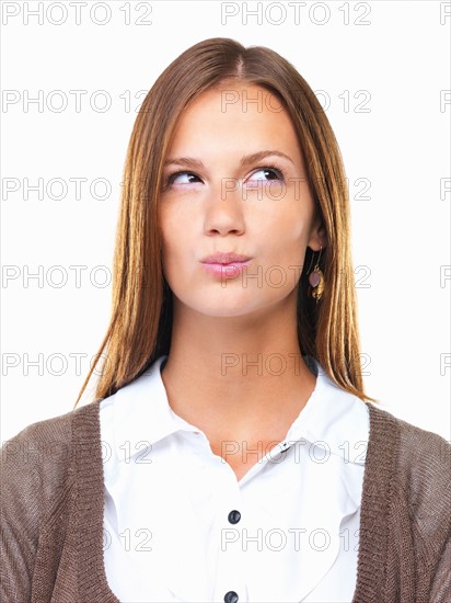 Close-up of business woman pursing her lips and looking up. Photo : momentimages